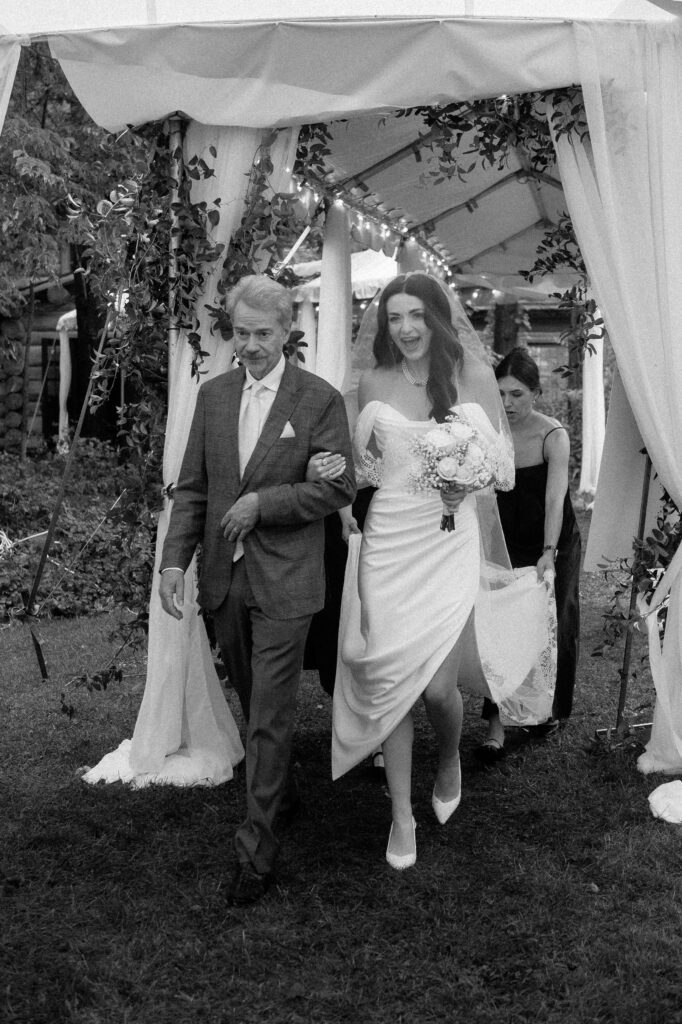 Bride walking down the aisle with father at River Wildlife tent ceremony