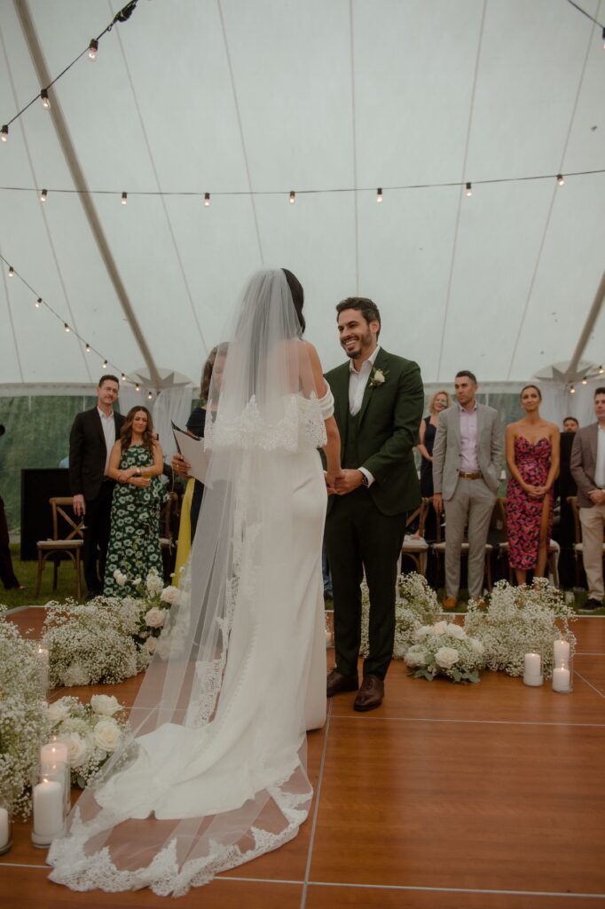 Bride and groom smiling at tent wedding ceremony in Kohler