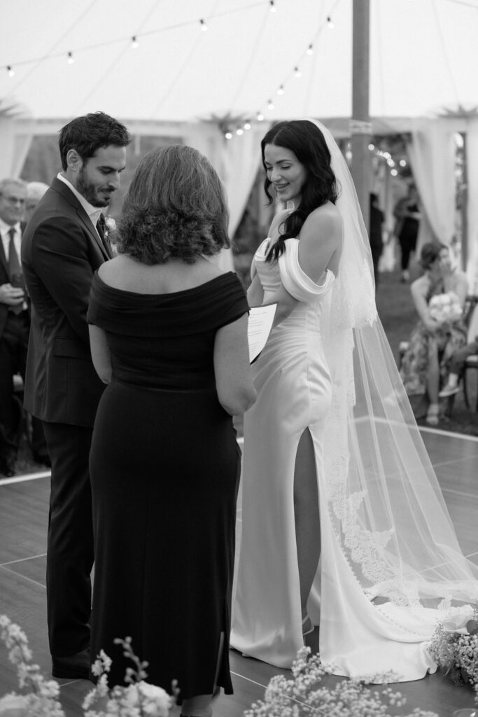 Bride and groom hold hands as they exchange vows at wedding ceremony in Kohler