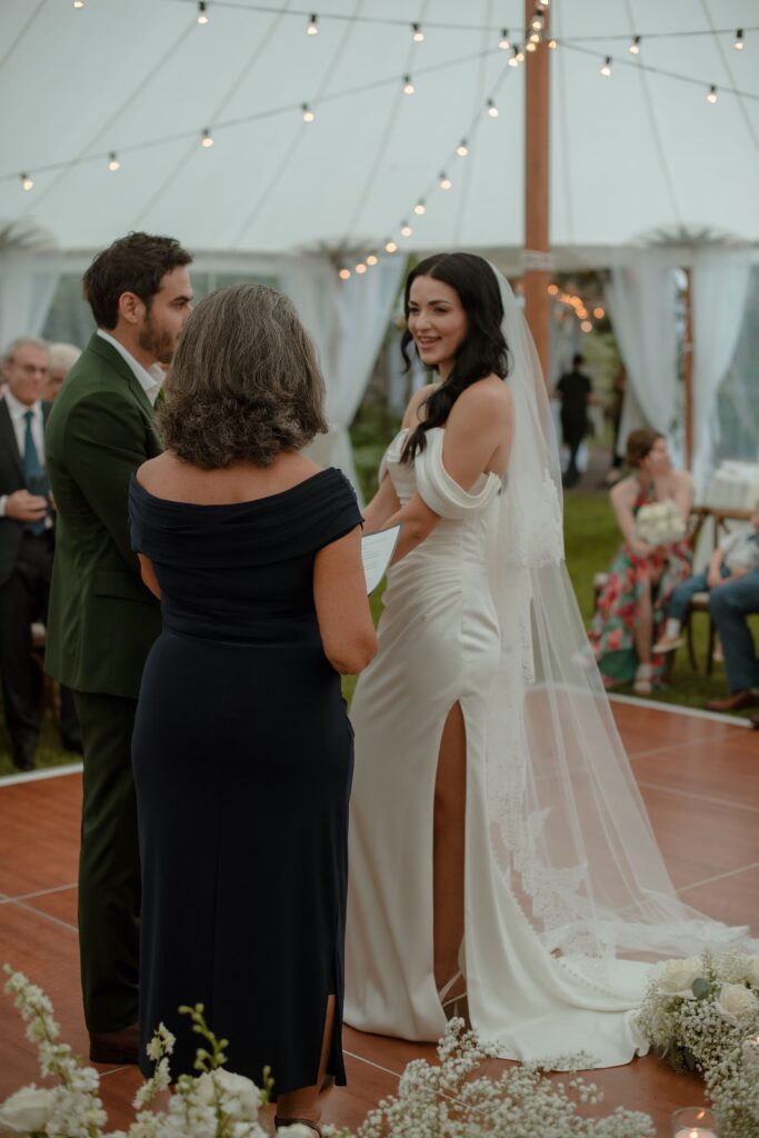 Bride and groom get married under a tent in the rain at River Wildlife in Kohler, WI