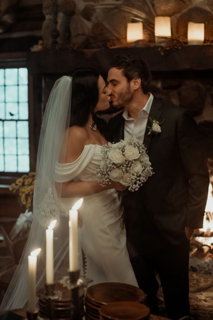 Bride and groom kiss in romantic cabin at River Wildlife in Kohler