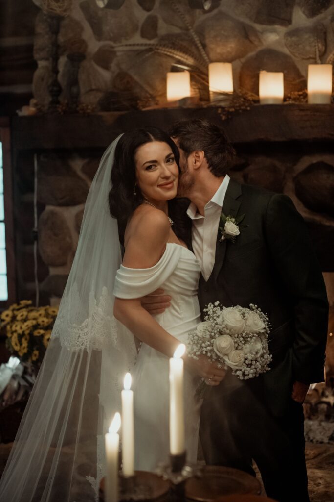 Groom kisses bride with romantic candles at River Wildlife in Kohler