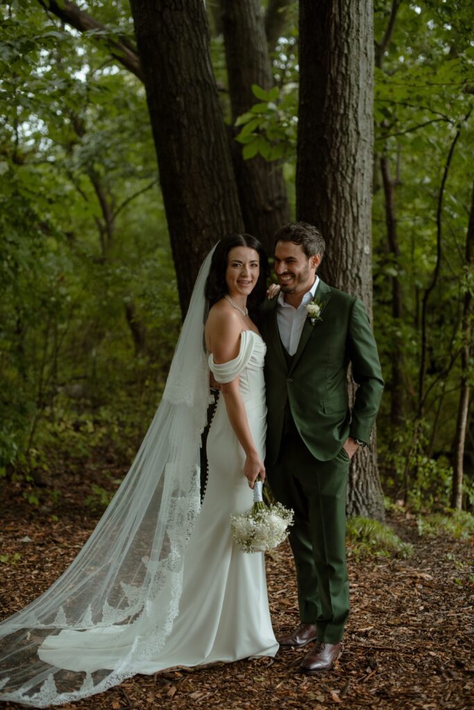 Wedding couple pose outdoors in the forest at River Wildlife in Kohler