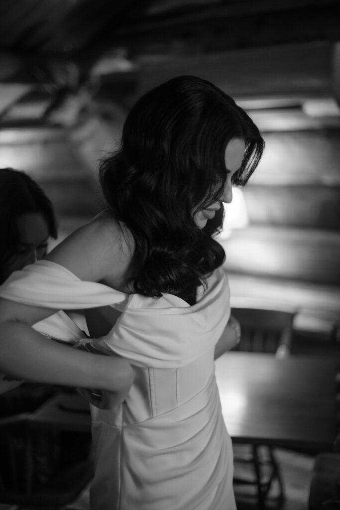 Bride putting on wedding gown at American Club in Kohler