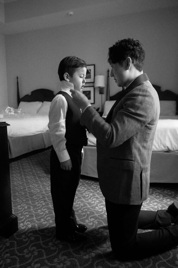 Father helps his son get ready at Pfister Hotel in Milwaukee before wedding