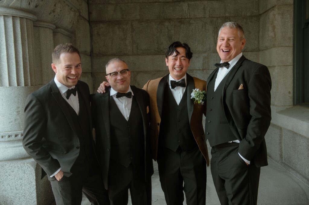 Groom and his groomsmen laugh together at the Pfister Hotel in Milwaukee