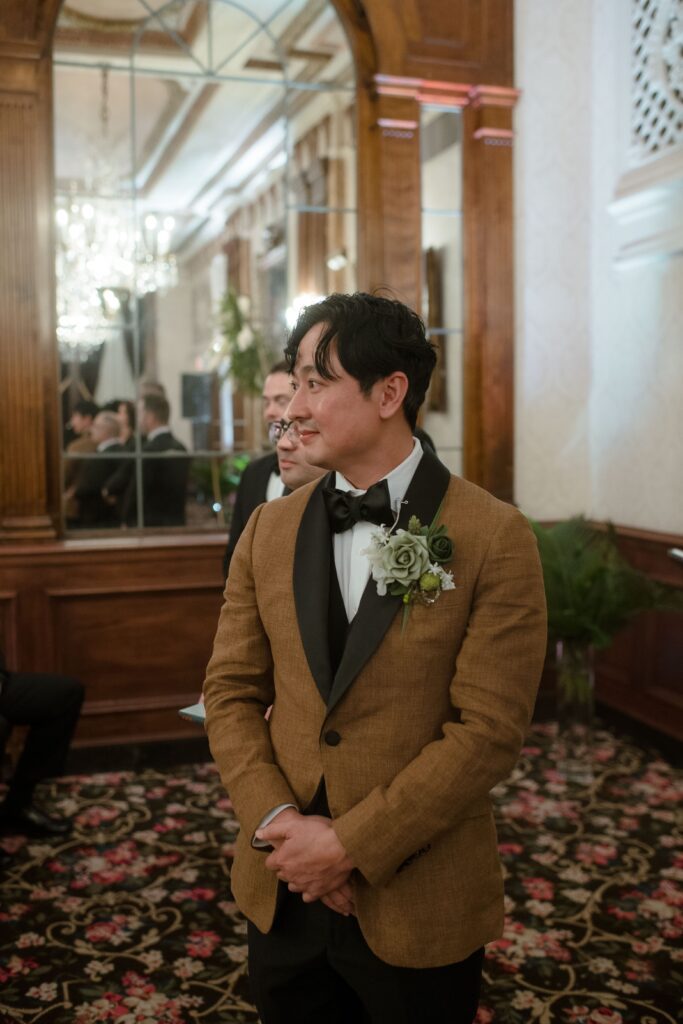 Groom watches his bride walk down the aisle at Pfister Hotel in Milwaukee