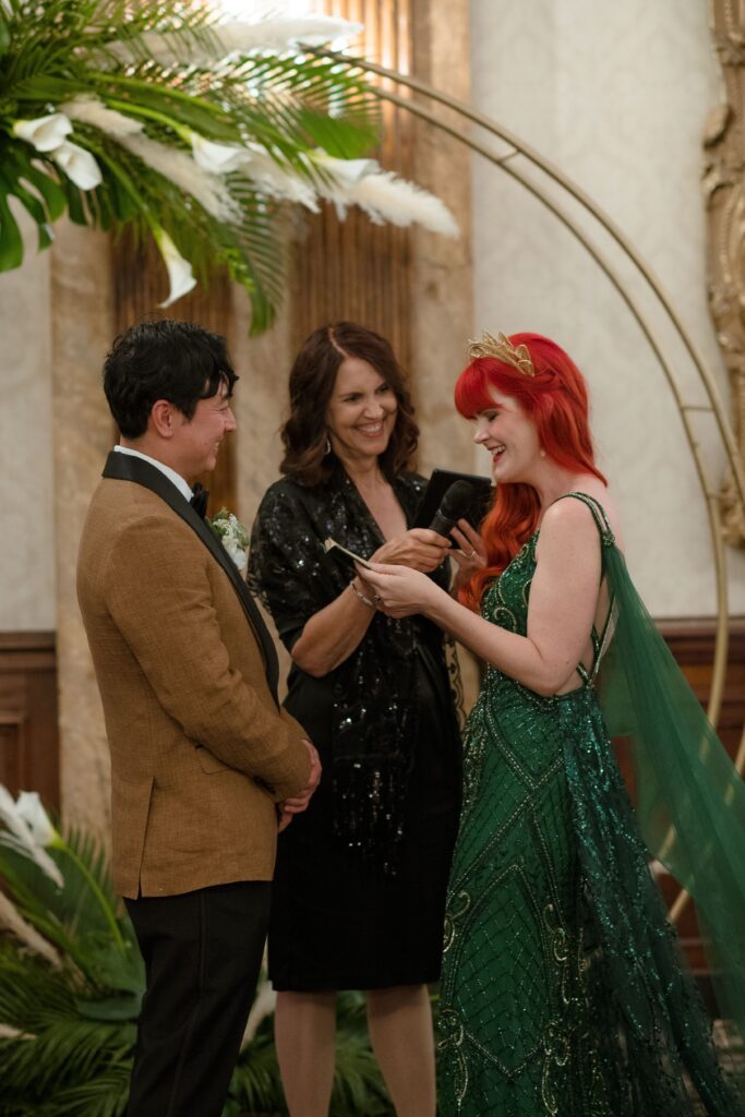 Bride and groom laugh as they read their vows at their wedding ceremony in Milwaukee at the Pfister Hotel