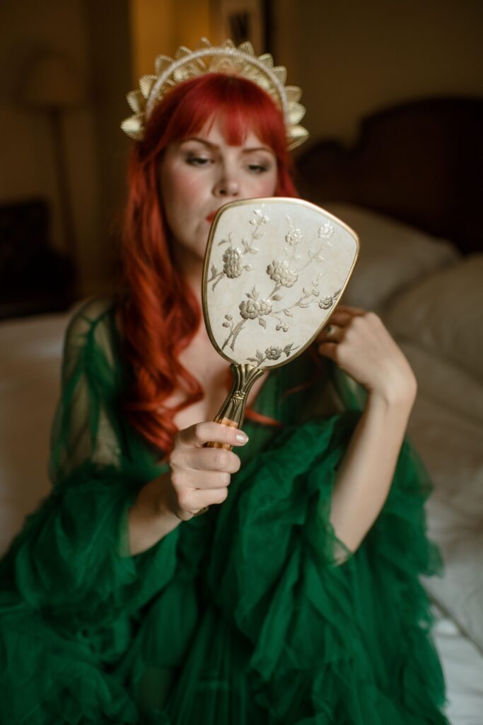 Bride looking in a mirror in hotel room in Milwaukee at the Pfister Hotel