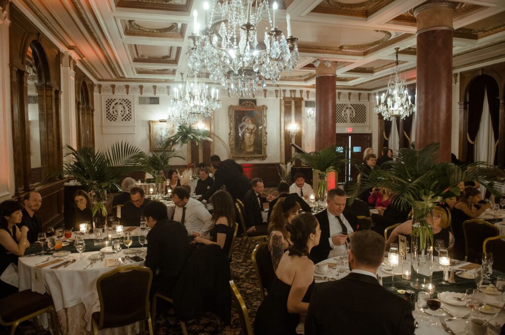 Guests chat at their tables under chandeliers at the Pfister Hotel