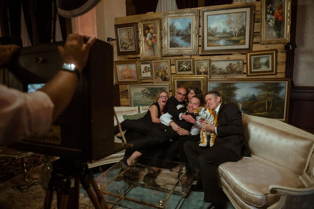 Family and friends pose with a tiger statute on a couch at the Pfister Hotel in Milwaukee