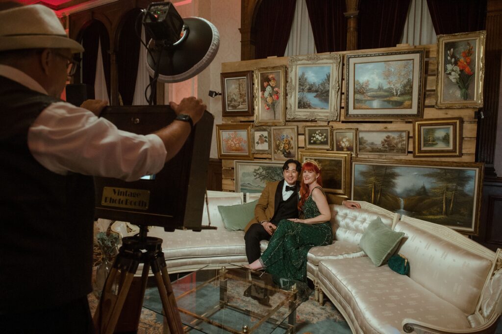 Bride and groom sit on a couch posing for a photo at the Pfister Hotel in Milwaukee