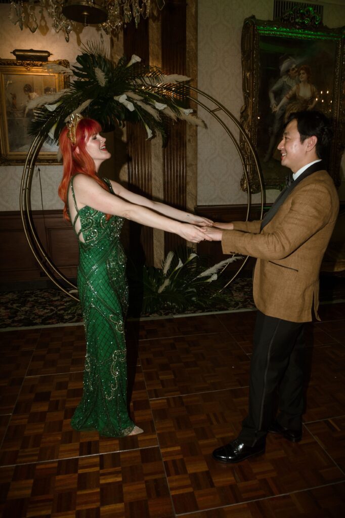 Bride and groom hold hands and dance at the Pfister Hotel in Milwaukee