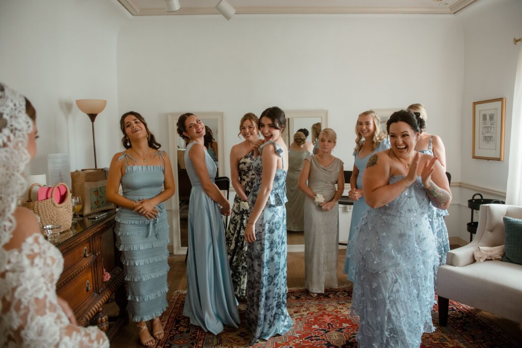 Bridesmaids smiling seeing bride for the first time