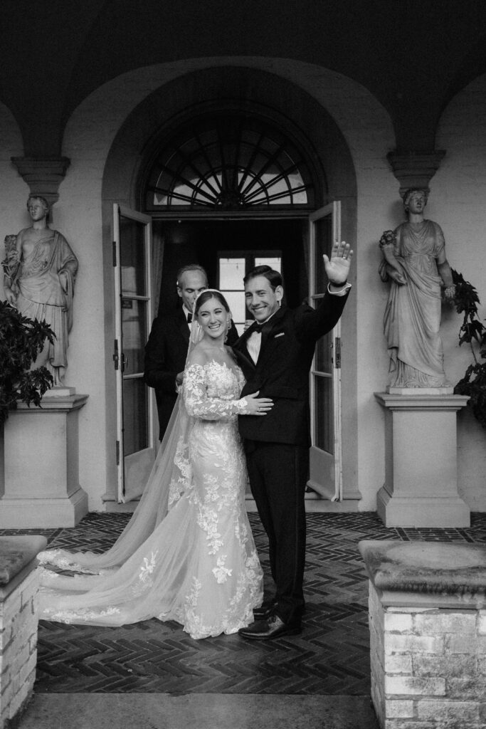 Bride and groom smile and wave after first kiss