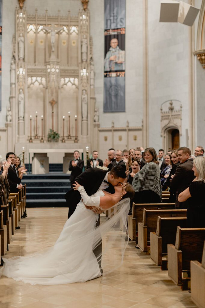Bride and groom kiss at Church of Gesu