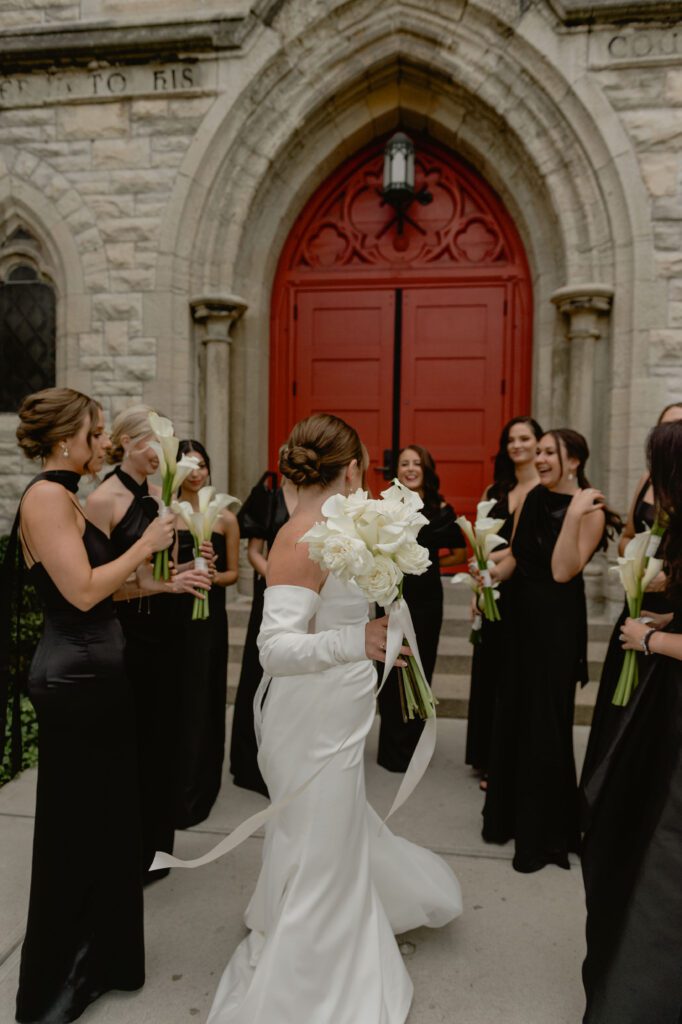 Bride with her bridal party outside of St. James 1868 on wedding day